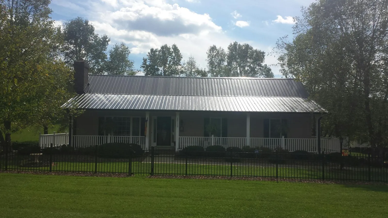 Gray metal roof on a brick ranch with a full width front porch — Gutter Guard Installation work by our crew in Capistrano Beach